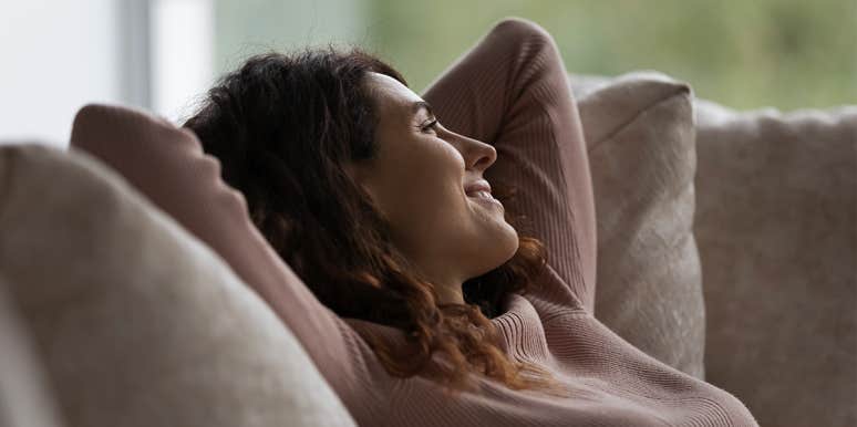 woman smiling relaxing on couch