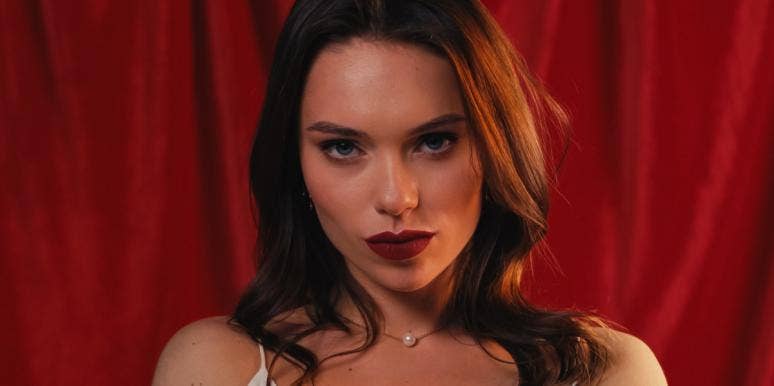 I Was The Other Woman In Several Relationships & Here’s What You Should Know woman in front of red curtain