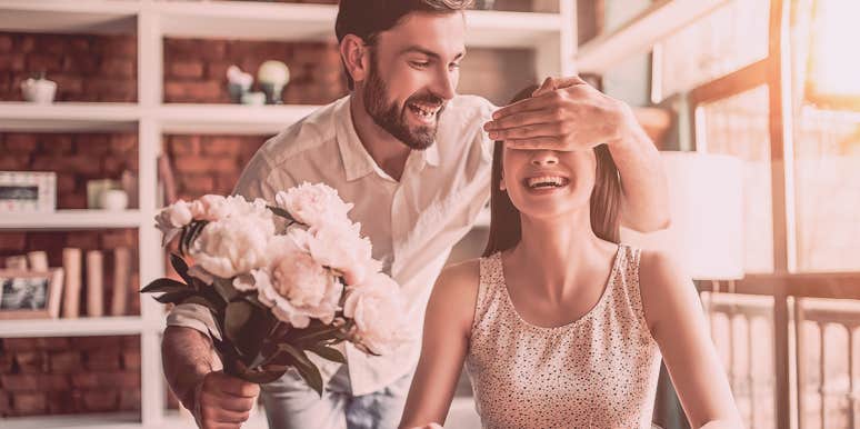 25 Signs He's Completely Hooked On You man handing flower to woman