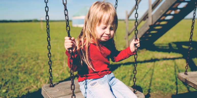 little girl crying on swing