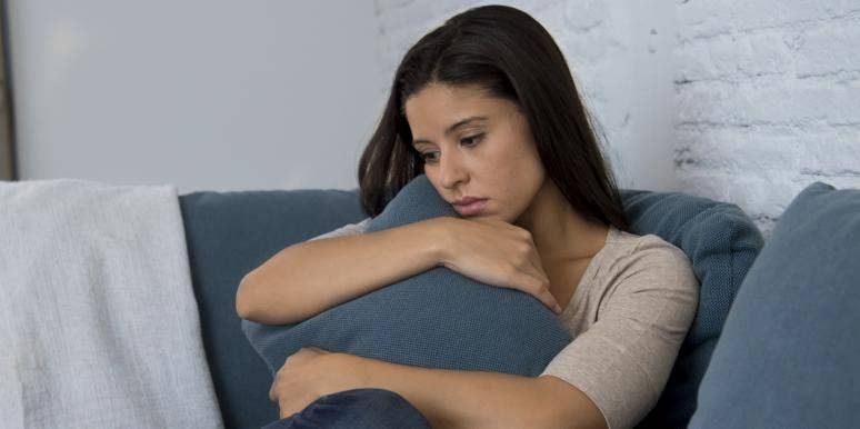 indifferent woman hugging a pillow