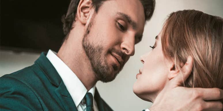 man holding woman's face about to kiss her
