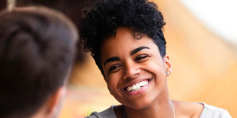 Young African-American woman smiles during conversation.