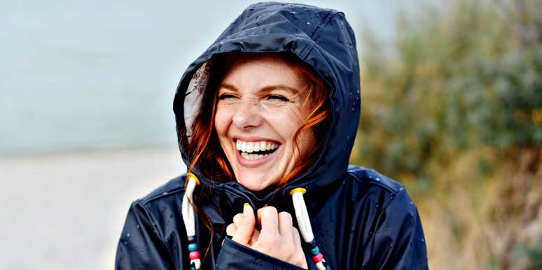 5 Ways Successful People Stay Calm In Chaos redhead woman with freckles laughing in raincoat