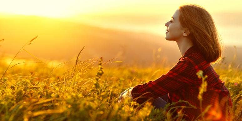 The Importance Of Knowing When To Slow Down In A Hectic World woman meditating in a field