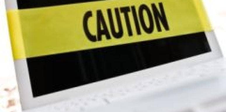 Online Dating: 7 Signs You Shouldn't Date Him laptop with caution tape across screen