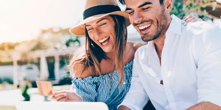 Launching Travel Saves You Up To 60% On Hotels This Summer man and woman smiling while looking at laptop