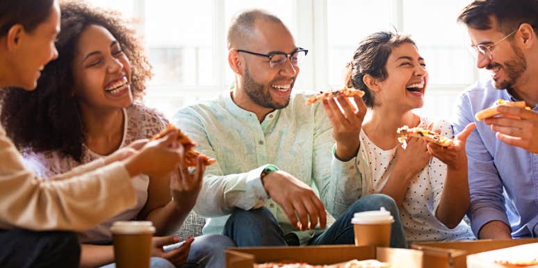 Group of co-workers share pizza and a laugh
