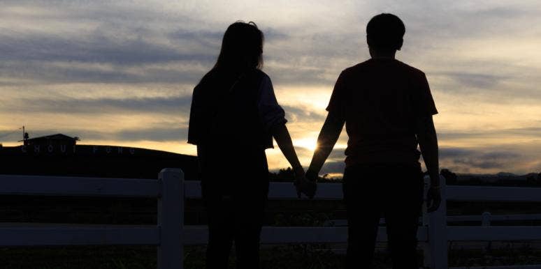 couple holding hands at sunset