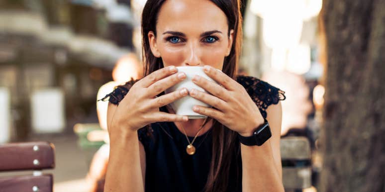 woman with blue eyes looking intensely over a cup