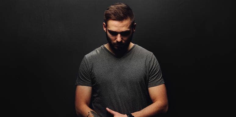 18 Men Reveal The Biggest White Lies They've Told Their Wives man looking down against black background