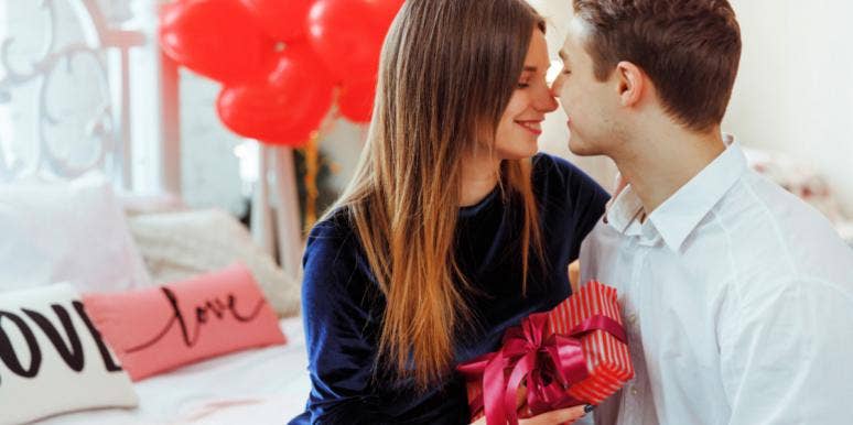 couple smiling on the couch holding valentines day presents