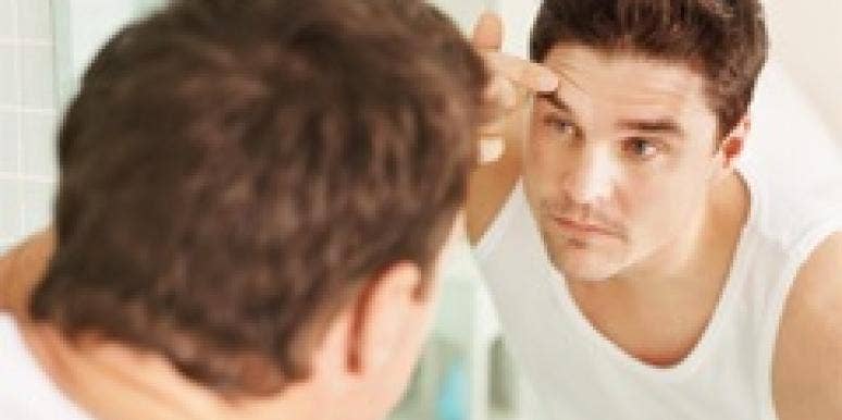 man primping in front of mirror
