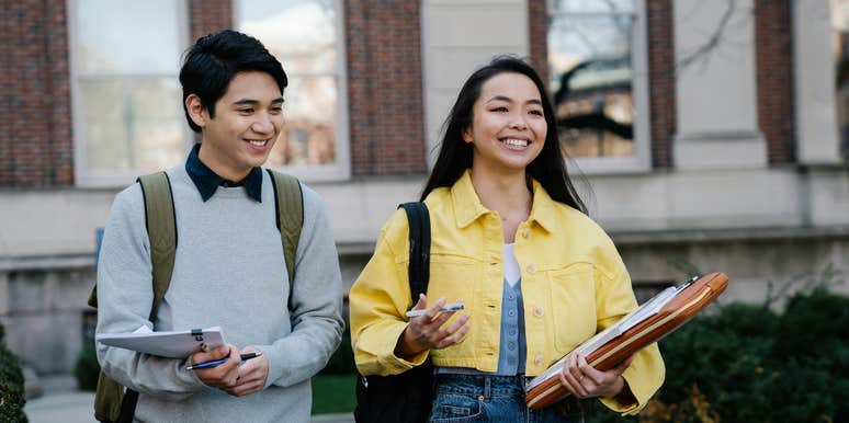 Young Man and Woman Walking Together On College Campus