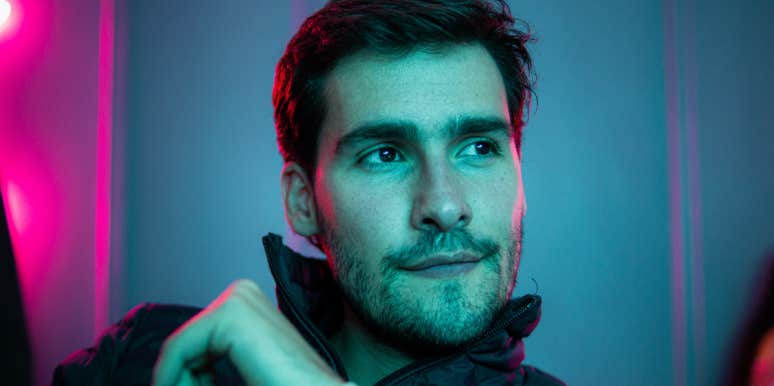 Man staring off-screen with neon background