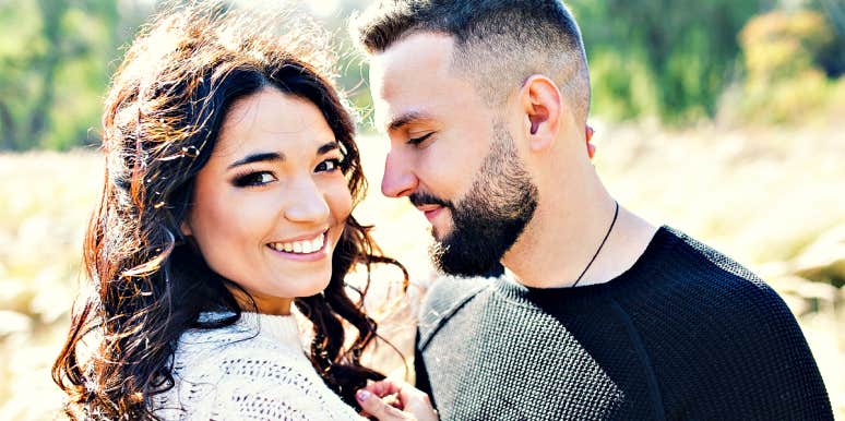 young man with beard looks lovingly at a young woman 