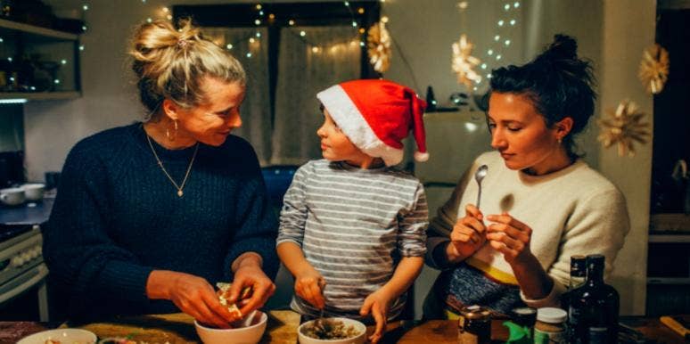grandmother and mother cooking with child in santa hat