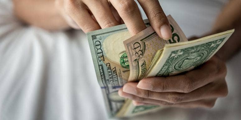 9 Methods Of Manifesting Money To Try When You're Broke person counting a stack of money