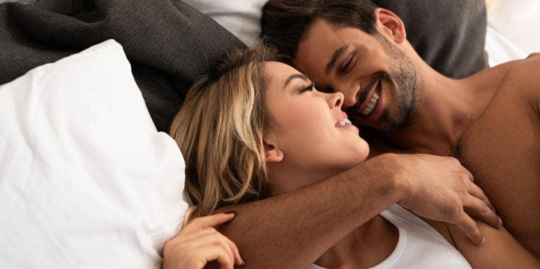 man and woman in bed cuddling