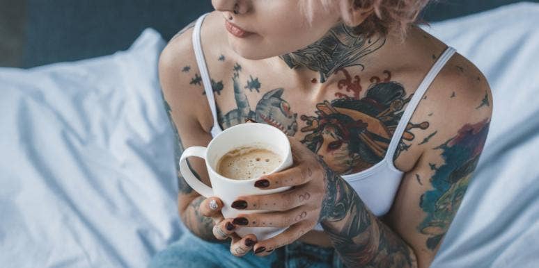 woman with tattoos holding coffee