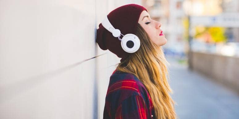 mind rest woman wearing beanie and headphones leaning on wall