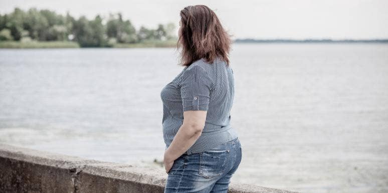overweight woman looking at water