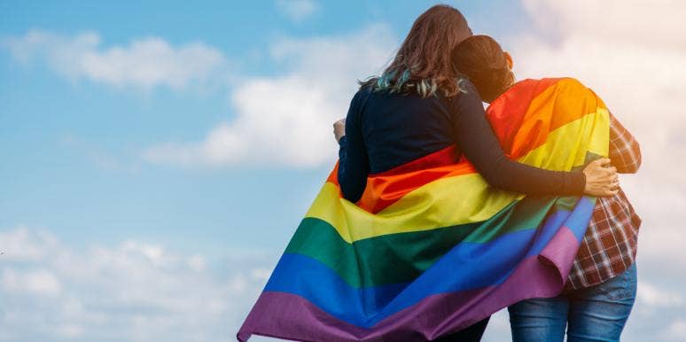 two women embracing under lgbt flag
