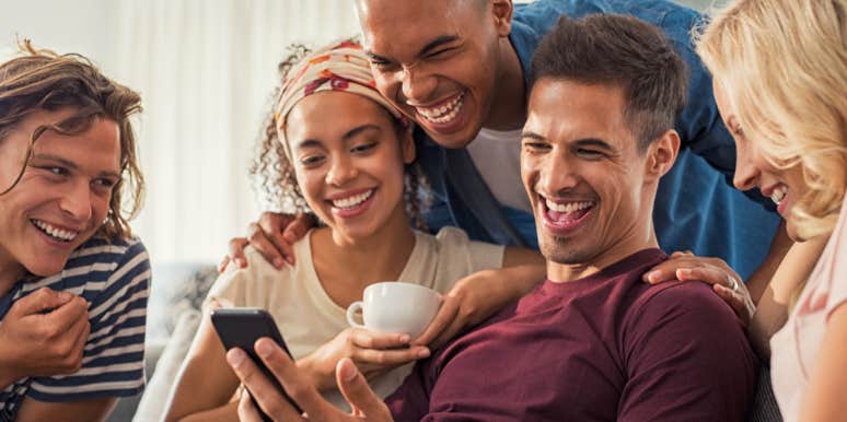 498 Best Most Likely To Questions (2022) friends laughing around a phone