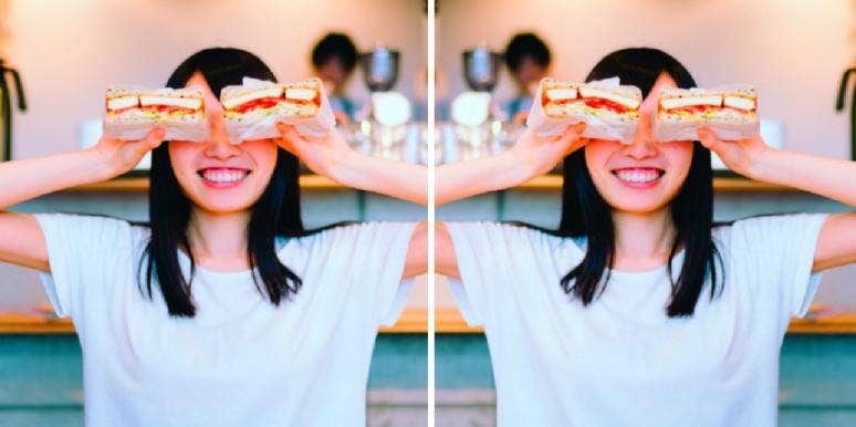 woman holding sandwich halves above her eyes