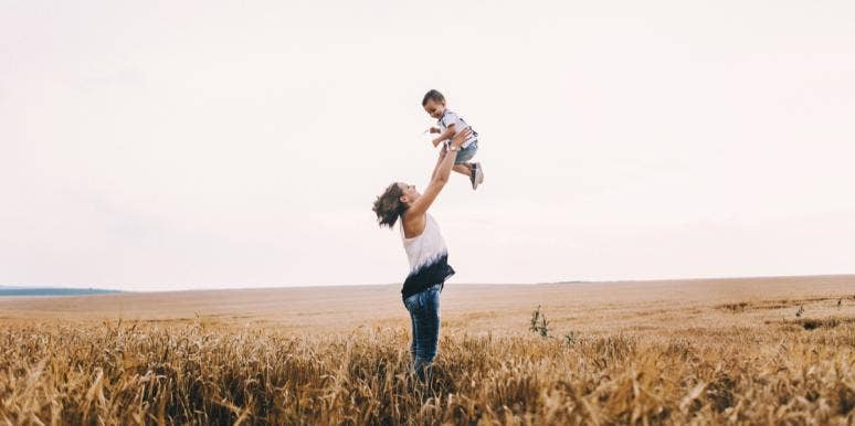 Motherhood As A Performance Sport mom holding baby up