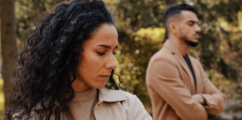 woman standing next to boyfriend who isn't listening to her