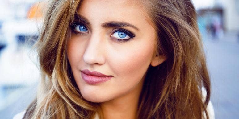 Why You Should Never Stop Looking For The Good In People woman with blue eyes staring and smirking