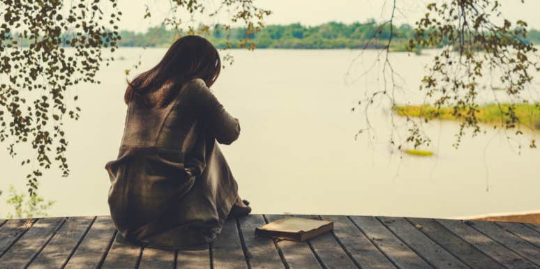 9 Big Signs You Have Borderline Personality Disorder (And May Not Know It) woman sitting by water holding her knees