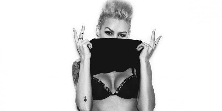 Nipple Piercings: Facts, Pros & Cons, And What To Know Before Getting Pierced woman in a bra holding up peace signs shirt over face