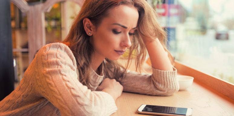 How The No Contact Rule Works: Why And When To Use It sad woman looking down at her phone