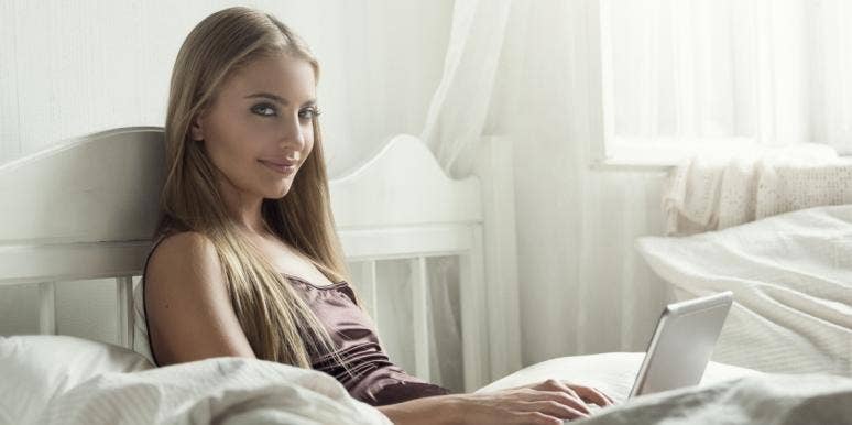 woman sitting on bed with laptop