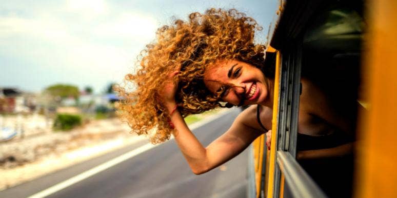 woman with head out the window hair blowing in wind