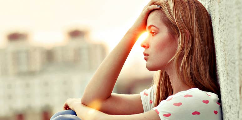 Reasons You Might Be Feeling Pessimistic About Life pessimistic woman, head in her hands as sun sets