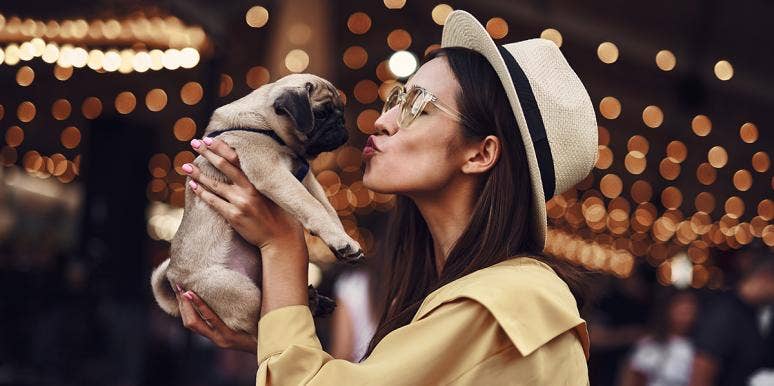 woman kissing puppy