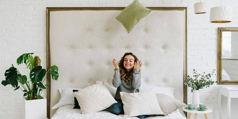 The Crazy Thing Your Throw Pillows Reveal About Your Relationship woman in bed with pillows