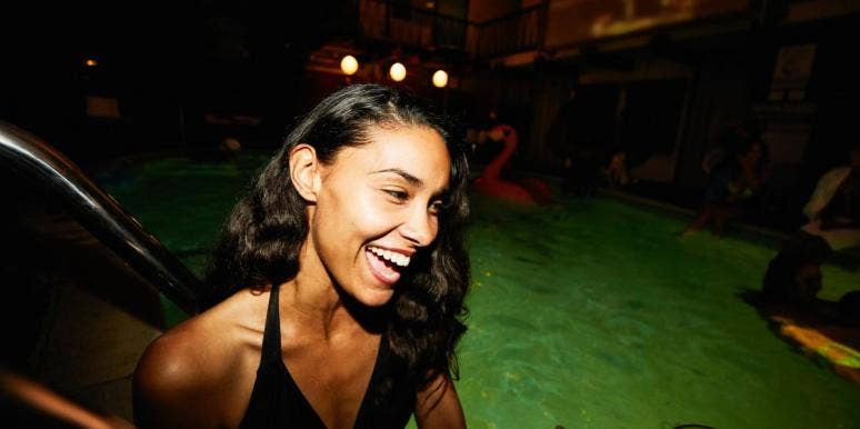 woman smiling on pool float in the dark