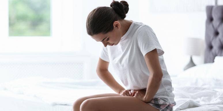 My Period Makes Me Suicidal: The Truth About PMDD a woman holding her stomach cramping
