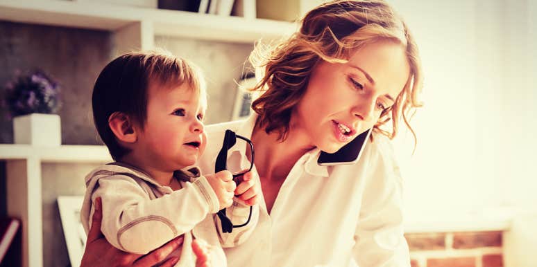 How To Cope When Everyone Expects You To Handle It All mother talks on phone while holding baby