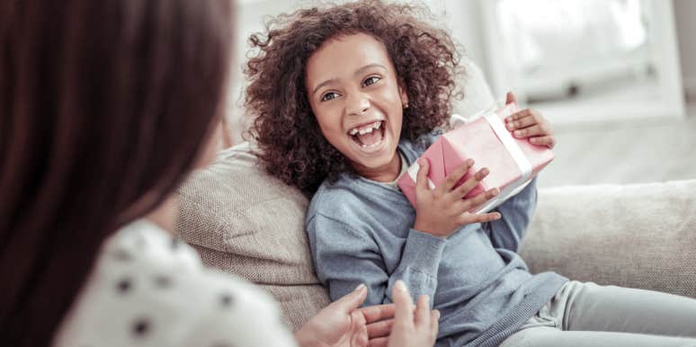 Mom Wonders If She's Wrong For Making 5-Year-Old Donate Gifts Her Ex's Family Gave Her little girl laughing while receiving gift