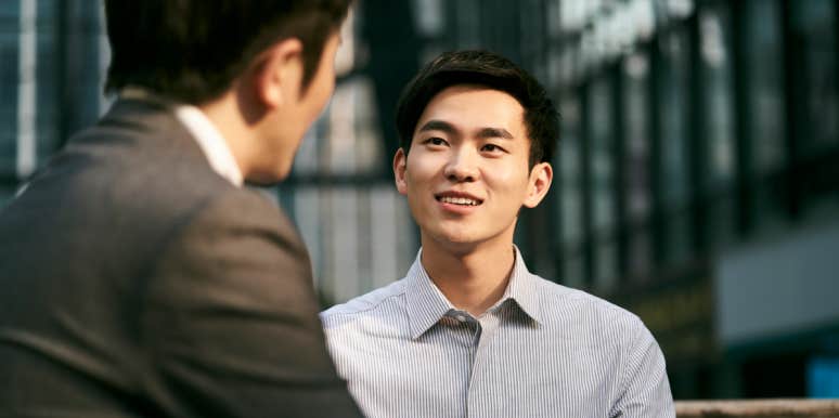Man Wonders If He's Wrong For Confronting His Wife's Boss About How 'Overworked' She Is Man talking to boss while at outdoor coffee shop