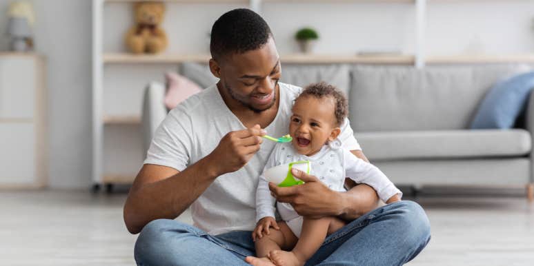 Man Wonders If He's Wrong For Requesting The 'Morning Off' From Taking Care Of His Newborn Baby dad feeding baby with spoon on carpet