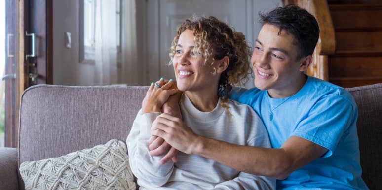 Mom Cancels Son's 17th Birthday Party After He Tells Her That 'Women Aren't Worth The Trouble' mom and teenage son embracing while sitting on a couch