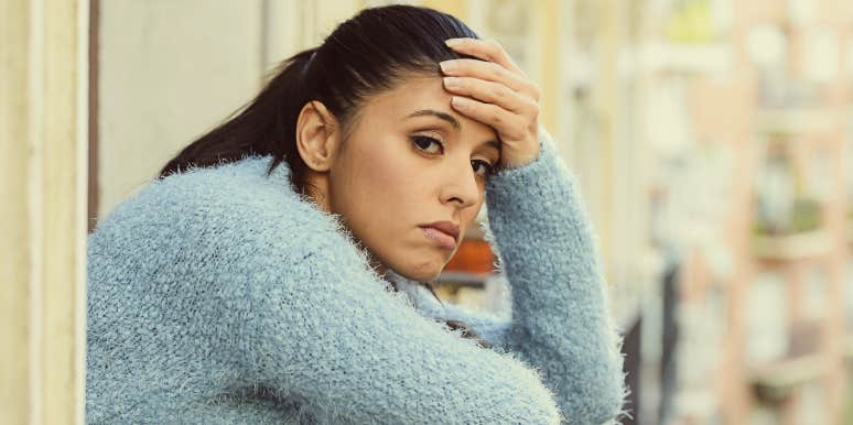 Relapsed addict Distraught woman looks out window.