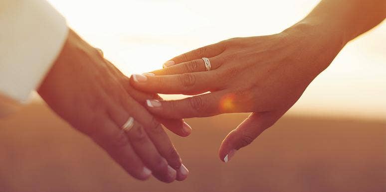 couple touching hands in sunset