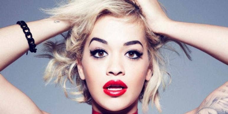Rita Ora, from the shoulders up, wearing black eyeliner and red lipstick in a Rimmel ad